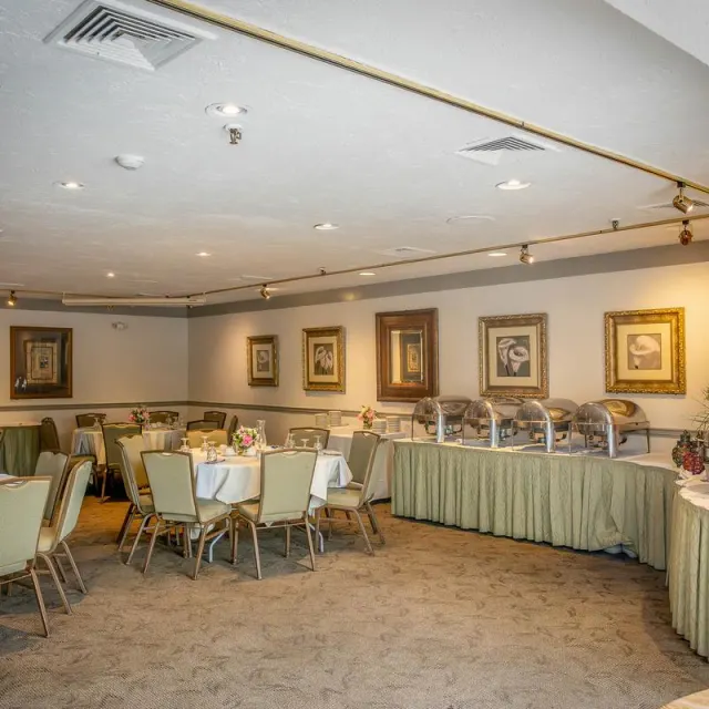 Banquet room with set tables and a buffet with chafing dishes