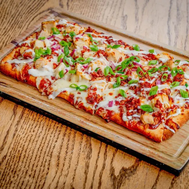 BBQ chicken flatbread on a wooden board
