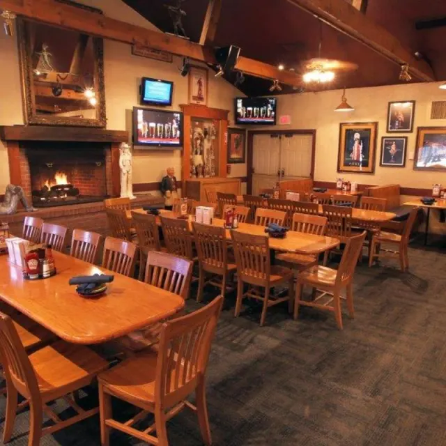 Dining area with a large brick fireplace and wooden tables